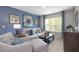 This bright living room features an accent wall, a cozy seating area, and a large window at 221 Friendship Oak Way, Hampton, GA 30228