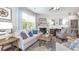 This living room features a large window, a sofa with pillows, a fireplace, an area rug, and two chairs at 221 Friendship Oak Way, Hampton, GA 30228