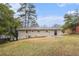 A rear exterior of a home with a grassy yard and mature trees at 2328 Starline Dr, Decatur, GA 30032
