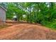 A large backyard with a small building on the property surrounded by trees at 1491 S Hairston Rd, Stone Mountain, GA 30088