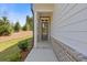 Inviting front porch with a glass door, brick accents, and white siding, offering a warm welcome at 1985 William Glen St, Dacula, GA 30019