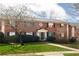 Charming two-story brick townhome with a manicured front lawn, bench, and welcoming entrance at 3535 Roswell Ne Rd # H2, Atlanta, GA 30305