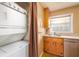 A compact kitchen corner with laundry equipment, a sink, and a window for ventilation at 3535 Roswell Ne Rd # H2, Atlanta, GA 30305