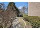 Well-manicured brick walkway leading through lush landscaping alongside exterior brick wall at 461 Wynns Way, Atlanta, GA 30331