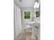 Traditional bathroom with pedestal sink, a shower, and a window overlooking the outdoors at 615 Spruce Dr, Pine Lake, GA 30072