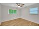 Minimalist bedroom with hardwood floors, neutral walls, and natural light from large windows at 615 Spruce Dr, Pine Lake, GA 30072