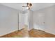 Simple bedroom with hardwood floors, ceiling fan, and open doorway to another room at 615 Spruce Dr, Pine Lake, GA 30072
