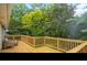 Large wooden deck surrounded by lush trees offering privacy and a serene outdoor space at 615 Spruce Dr, Pine Lake, GA 30072