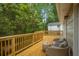 Wooden deck with outdoor seating overlooking the lush, wooded backyard at 615 Spruce Dr, Pine Lake, GA 30072
