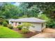 Well maintained home with an orange front door, neutral siding, landscaping, and mature trees on a grassy lawn at 615 Spruce Dr, Pine Lake, GA 30072