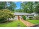 Charming single story home with mature trees and a lovely stone walkway to the bright orange front door at 615 Spruce Dr, Pine Lake, GA 30072