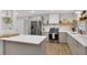 Well-equipped kitchen with a large island, stainless appliances, light gray cabinets, and quartz countertops at 615 Spruce Dr, Pine Lake, GA 30072