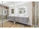 This modern bathroom features a double vanity with sleek gray cabinetry, a glass-enclosed shower, and a large, illuminated mirror at 1908 Variations Ne Dr, Atlanta, GA 30329