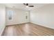 A bright vacant bedroom featuring wood laminate floors, a ceiling fan and two windows at 1908 Variations Ne Dr, Atlanta, GA 30329