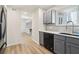 Modern kitchen with stainless steel appliances, gray cabinets, and hardwood floors leading to the living area at 1908 Variations Ne Dr, Atlanta, GA 30329