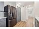 Bright kitchen with stainless steel refrigerator, gray cabinets, and hardwood floors leading to the living area at 1908 Variations Ne Dr, Atlanta, GA 30329