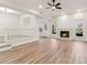 Open-concept living room with fireplace, ceiling fan, hardwood floors, and neutral color palette at 1908 Variations Ne Dr, Atlanta, GA 30329