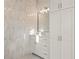 Bathroom featuring a white vanity with marble countertop and decorative, vertically laid tile at 5060 Lake Forrest Dr, Atlanta, GA 30342