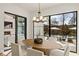 Contemporary dining room with a wood table, seating for six, and backyard pool views at 5060 Lake Forrest Dr, Atlanta, GA 30342