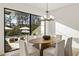 Modern dining room with backyard view, wood table, seating for six and contemporary chandelier at 5060 Lake Forrest Dr, Atlanta, GA 30342