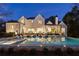 Stunning exterior view of the home showcasing the sparkling pool and elegant architecture at twilight at 5060 Lake Forrest Dr, Atlanta, GA 30342