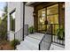 Inviting front porch with black iron railing and a modern glass front door at 5060 Lake Forrest Dr, Atlanta, GA 30342