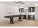 Finished basement game room featuring a shuffleboard table and wet bar with black cabinets at 5060 Lake Forrest Dr, Atlanta, GA 30342