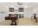Game room featuring a shuffleboard table, wet bar with beverage cooler, and light wood floors at 5060 Lake Forrest Dr, Atlanta, GA 30342