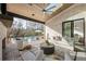 Spacious covered outdoor living area with pool view, fireplace, fan, and white brick wall at 5060 Lake Forrest Dr, Atlanta, GA 30342