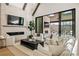 Bright living room featuring a stone fireplace, large TV, and expansive glass doors to the patio at 5060 Lake Forrest Dr, Atlanta, GA 30342