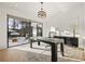 Well-lit home office with pool view, dark wooden desk, and modern decor at 5060 Lake Forrest Dr, Atlanta, GA 30342