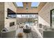 Covered patio with fireplace, tv, and outdoor seating overlooking a pool area and wooded backyard at 5060 Lake Forrest Dr, Atlanta, GA 30342