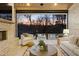 Covered patio with fireplace, tv, and outdoor seating overlooking a pool area and wooded backyard at sunset at 5060 Lake Forrest Dr, Atlanta, GA 30342