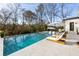 Backyard pool with sun loungers, umbrellas, and a wooded surrounding landscape at 5060 Lake Forrest Dr, Atlanta, GA 30342