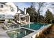 Backyard pool with sun loungers, umbrellas, and a wooded surrounding landscape at 5060 Lake Forrest Dr, Atlanta, GA 30342