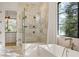 Modern tiled shower with glass enclosure next to luxurious soaking tub and large window at 5060 Lake Forrest Dr, Atlanta, GA 30342
