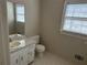 Bright bathroom featuring a single vanity, large mirror, and window at 6420 Phillips Pl, Lithonia, GA 30058