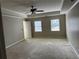 Bedroom featuring neutral carpet, tray ceilings, and large double windows at 6420 Phillips Pl, Lithonia, GA 30058