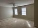 Neutral bedroom with two windows, ceiling fan, and plush carpeting at 6420 Phillips Pl, Lithonia, GA 30058