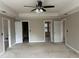 Spacious bedroom with neutral carpet, ceiling fan, and multiple entryways at 6420 Phillips Pl, Lithonia, GA 30058