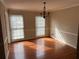 Bright dining room with hardwood floors, large windows, and decorative lighting fixture at 6420 Phillips Pl, Lithonia, GA 30058