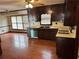Kitchen with wooden cabinets, stainless steel dishwasher, and hardwood floors at 6420 Phillips Pl, Lithonia, GA 30058
