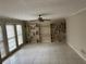 Spacious living room featuring tile flooring, a ceiling fan, and built-in shelving at 6420 Phillips Pl, Lithonia, GA 30058