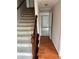 Carpeted staircase with wood railing and hardwood floors in the foyer at 6420 Phillips Pl, Lithonia, GA 30058