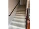 Carpeted staircase with wood railing leading to the upper level of the home at 6420 Phillips Pl, Lithonia, GA 30058
