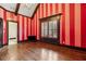 Bright bedroom featuring hardwood floors, striped accent wall, and a window with wooden shutters at 2353 Habersham Sw Dr, Marietta, GA 30064
