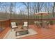 Relaxing deck area with outdoor seating, a table, and a patio umbrella, surrounded by a tranquil wooded setting at 2353 Habersham Sw Dr, Marietta, GA 30064