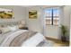 Cozy staged bedroom with a comfortable bed, artwork, and natural light from a window at 475 Mount Vernon Ne Hwy # C230, Sandy Springs, GA 30328