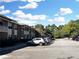 Exterior view of apartments showing parking and green space with a blue sky at 475 Mount Vernon Ne Hwy # C230, Sandy Springs, GA 30328