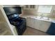 Efficient kitchen featuring white cabinets, laminate countertops, and a black electric range at 533 Fayetteville Rd, Fairburn, GA 30213